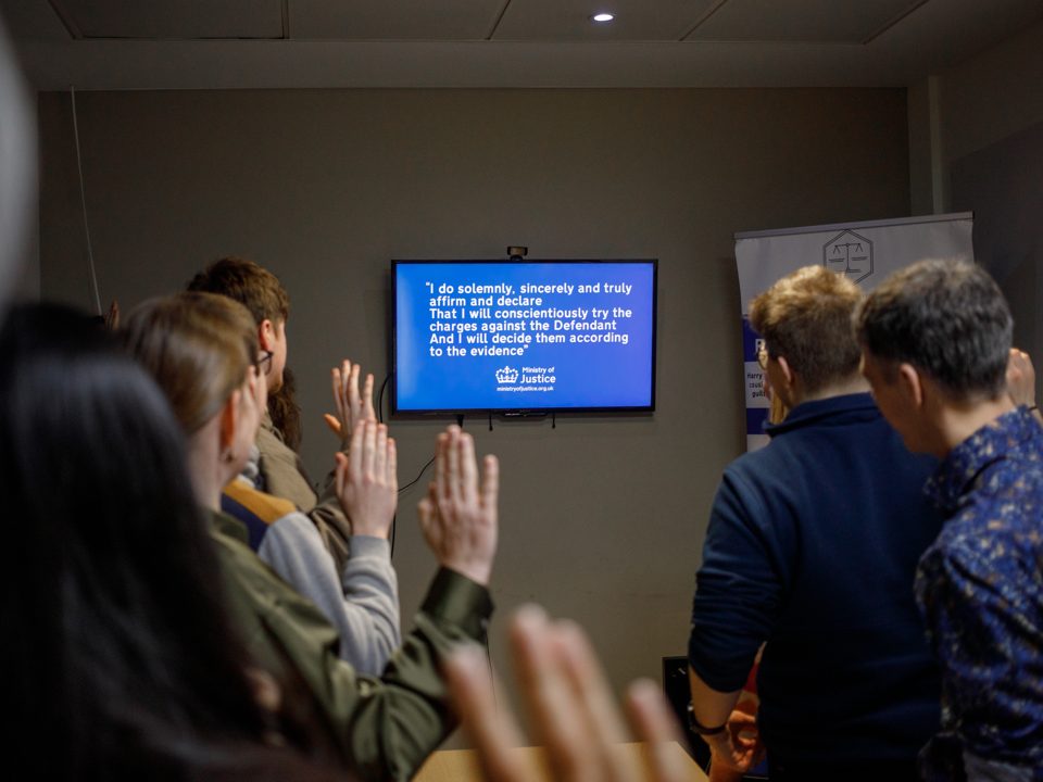 Jurors raise their hands to cast a verdict.