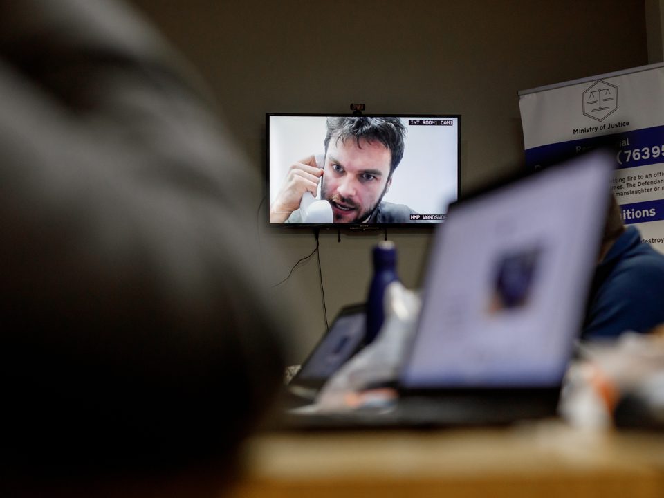 The live defendant answers questions on screen during a Jury Duty session.